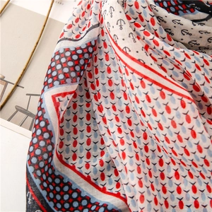 Detail view of lightweight linen-touch scarf featuring nautical anchor and red fish patterns
