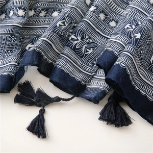 Macro detail of retro blue floral print scarf fabric with braided tassels
