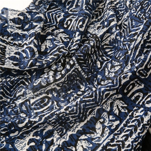 Gros plan sur la texture en lin tissé et l'imprimé ethnique bleu du long foulard