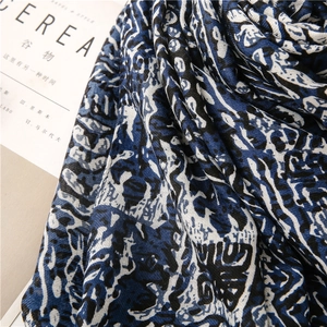 Vue détaillée d'une écharpe à motifs abstraits bleu et noir avec texture textile