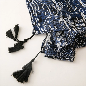 Détail macro du tissu à motif géométrique abstrait avec des pompons noirs noués à la main