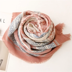 Detail of bohemian geometric pattern on soft pink and cream scarf with fringe edges