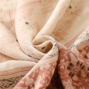 Detailed view of the woven linen texture and geometric patterns on a soft shawl scarf