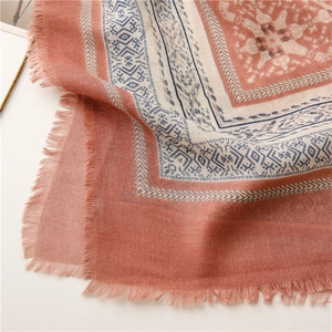 Detail of soft brick red and cream geometric ethnic pattern scarf with delicate fringe
