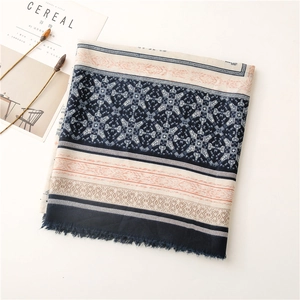 Detailed close-up of navy and orange geometric patterns with soft fringe on a linen scarf