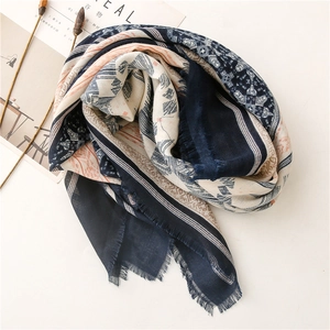 Detailed view of geometric ethnic print scarf with soft fringe edges and navy patterns