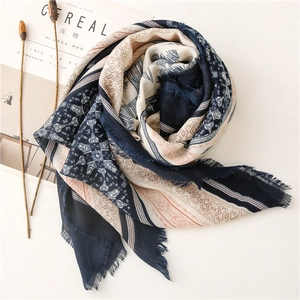 Detail of tribal geometric print scarf with frayed edges in navy and orange tones