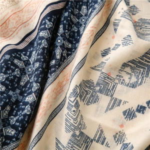 Detailed macro view of geometric ethnic pattern on soft navy blue and orange woven scarf