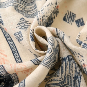 Detail of linen-feel scarf featuring geometric ethnic patterns and soft fringed edges