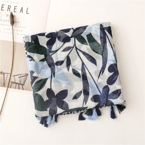Detail of blue botanical cherry leaf print on linen-feel scarf with handmade tassels