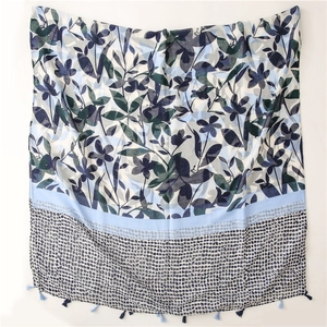 Detail of cotton linen scarf with blue cherry leaf print and handmade fringe tassels