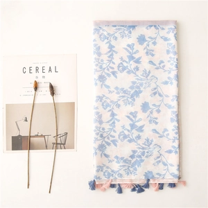 Pink and blue leaf print scarf with tassels on white background with dried flowers