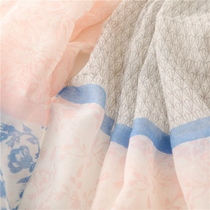 Close-up of lightweight floral scarf showing pink petals and blue vintage leaf patterns