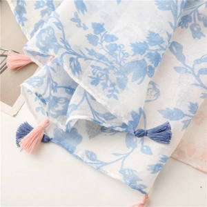Detail of floral print scarf with soft tassels and breathable cotton linen texture