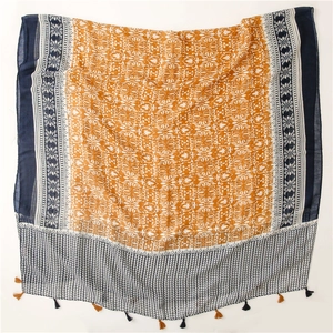 Dettaglio di sciarpa vintage in cotone e lino con motivi floreali arancioni e nappe