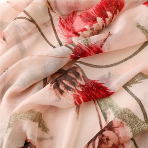 Detail van rode bloemenprint op roze katoenen linnen sjaal met zachte franjes