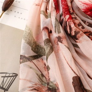Detailopname van de roze sjaal met bloemenprint en ademende mesh-textuur