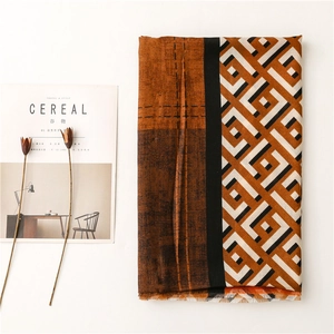 Detail view of cotton linen scarf with geometric diamond pattern and frayed edges
