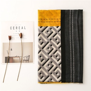 Close-up of contrast color patchwork scarf with fringed edges and geometric patterns