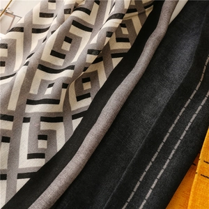 Detail of soft gray and black geometric F-pattern scarf with frayed edges and thick texture