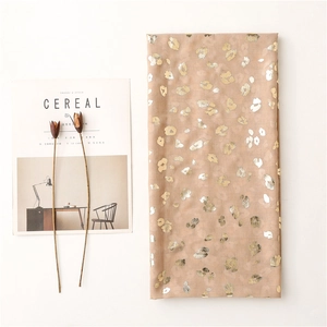 Detail of champagne scarf with gold foil leopard print and soft linen texture