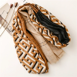 Detail of color-block geometric shawl with frayed edges in brown, black and beige