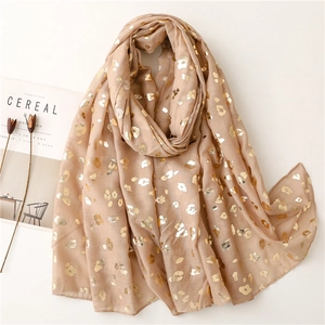 Detail of light beige scarf featuring golden foil leopard patterns and soft rolled edges