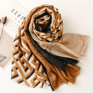 Close-up of color block scarf with earth tones, geometric patterns and fringe detail