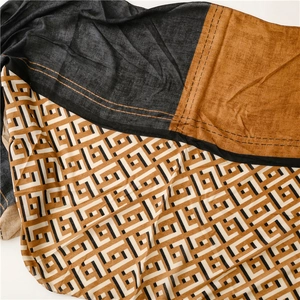Close-up of geometric pattern scarf with contrast color trim and fringe detail