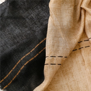 Close-up of color-block scarf texture with fine fringe edges and woven stripe detail