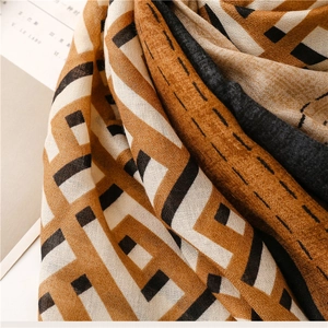 Close-up of geometric square pattern shawl featuring premium wool texture and frayed edges