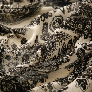 Gros plan sur l'écharpe en fil de Bali avec imprimé paisley noir et texture du tissu