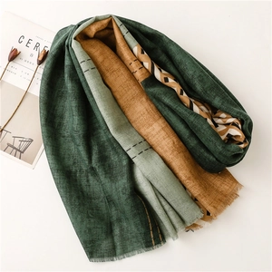 Detail of color-block scarf with fine fringe edges and textured geometric patterns