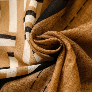 Macro view of patterned scarf texture showing earthy tones and soft woven fabric folds