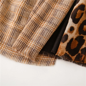 Detail of leopard print and brown plaid textures on a soft cotton linen frayed shawl
