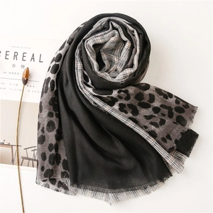 Detailed view of leopard print and houndstooth patchwork scarf with raw frayed edges