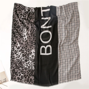 Detail of color-block scarf featuring leopard print, BONIT text and houndstooth patterns