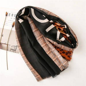 Detail of leopard print and houndstooth scarf with stylish frayed fringe edges