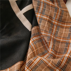Close-up of contrast scarf showing fine cotton linen texture and bold geometric H pattern