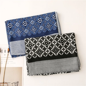 Detailed view of kaleidoscope pattern silk scarves with navy and black geometric designs
