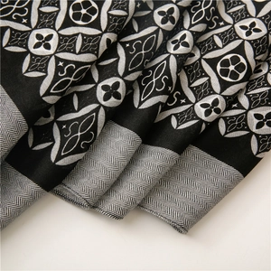 Close-up of black and white kaleidoscope pattern scarf with herringbone woven edges