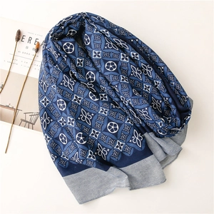 Detail of navy blue kaleidoscope pattern scarf with grey herringbone border on white back