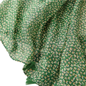 Green daisy print voile scarf with tassels for sun protection and travel wear