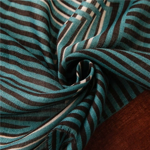 Détail d'une écharpe en lin à rayures bleues et brunes avec franges et tissage doux