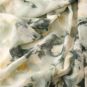 Close-up of soft cotton-linen scarf with green abstract ink painting texture and drape