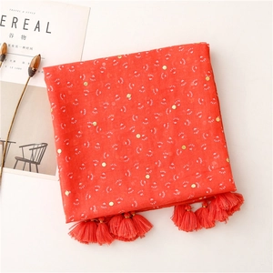 Detail of red floral cotton linen shawl with gold foil accents and fringe edges