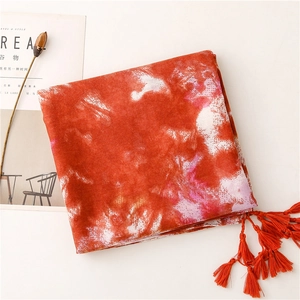 Detail of red tie-dye cotton scarf with dense fringe tassels and elegant texture