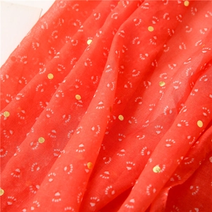 Detail of orange cotton-linen scarf featuring white paw prints and gold foil polka dots