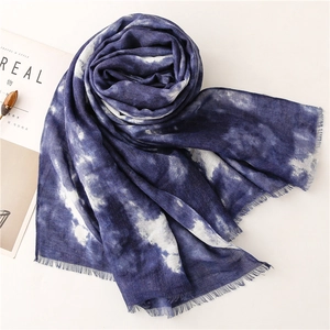 Dettaglio della sciarpa tie-dye blu e bianca con frange sottili e consistenza in cotone