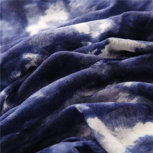 Dettaglio della sciarpa in cotone e lino con trama intrecciata tie-dye etnica blu e bianca